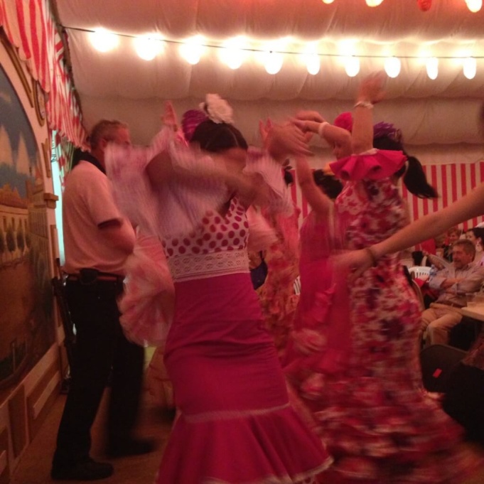 The women dancing in the traditional Flamenco-style dress.